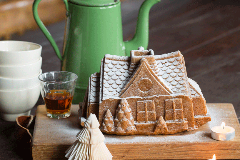 cake in de vorm van een besneeuwd boerderijtje met poedersuiker
